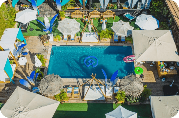 A swimming pool area in the sun with the CS brand logo floating on the surface